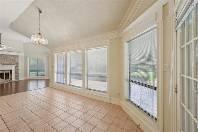 4711 Burns Cir, Orange, TX 77630 - unfurnished living room featuring light tile patterned floors, a textured ceiling, ornamental molding, a chandelier, and a fireplace with raised hearth