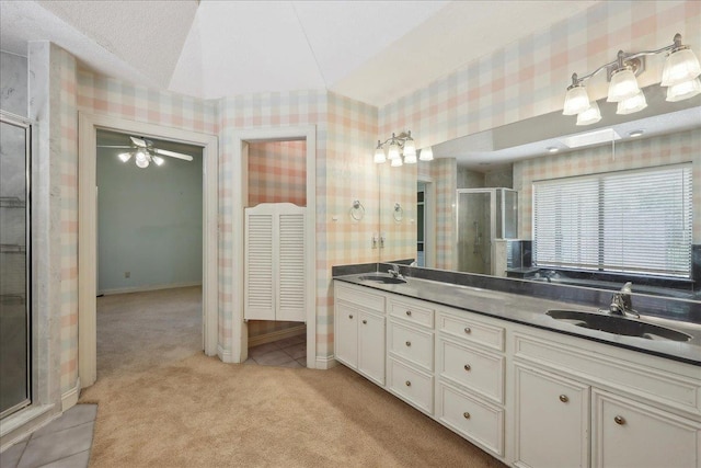 4711 Burns Cir, Orange, TX 77630 - full bath featuring wallpapered walls, double vanity, a shower stall, ceiling fan, and tile patterned floors
