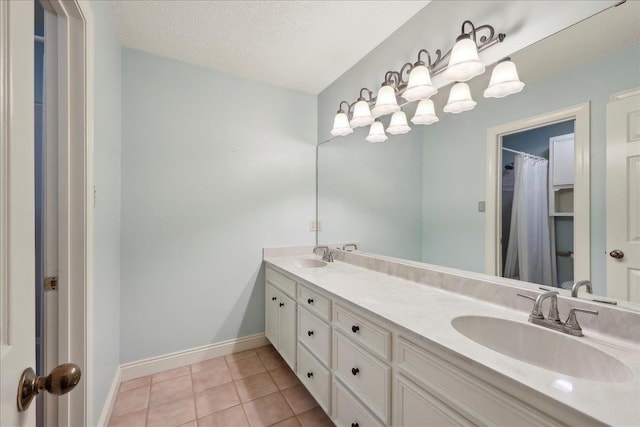 4711 Burns Cir, Orange, TX 77630 - full bathroom with double vanity, tile patterned floors, baseboards, and a textured ceiling