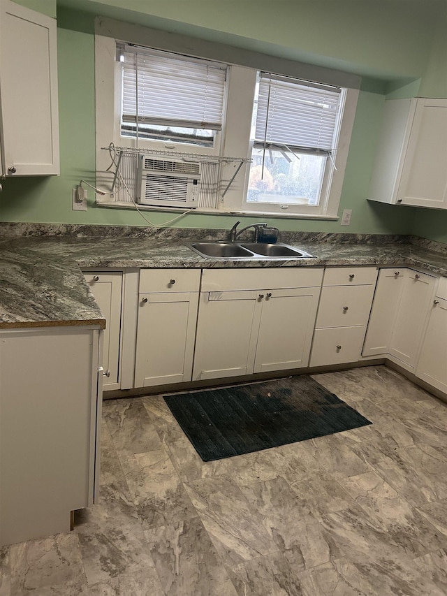 kitchen featuring white cabinetry, sink, cooling unit, and dark stone counters