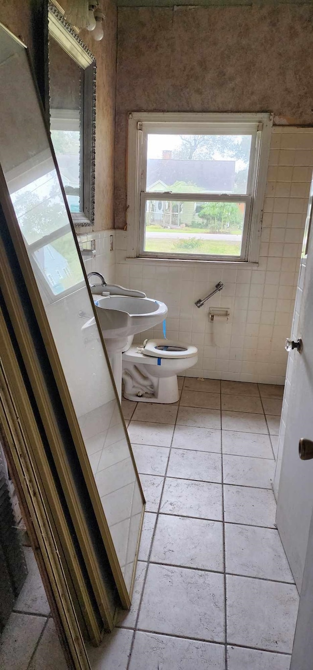 bathroom featuring tile patterned floors, sink, toilet, and tile walls