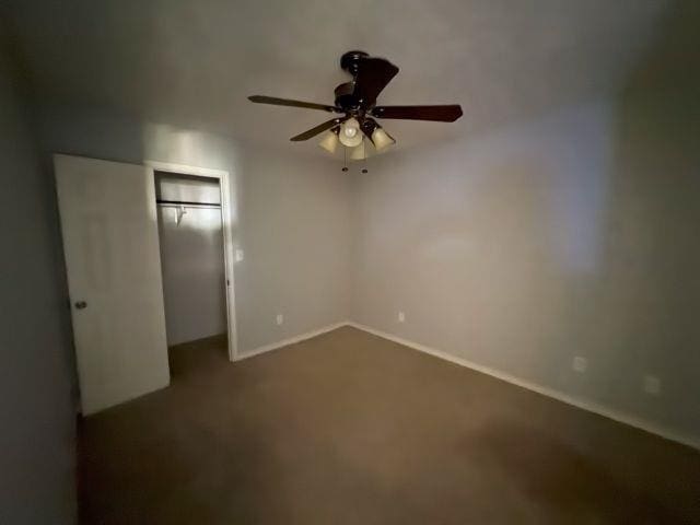 2985 Willow Pl, Beaumont, TX 77707 - unfurnished bedroom with dark carpet, a closet, and a ceiling fan