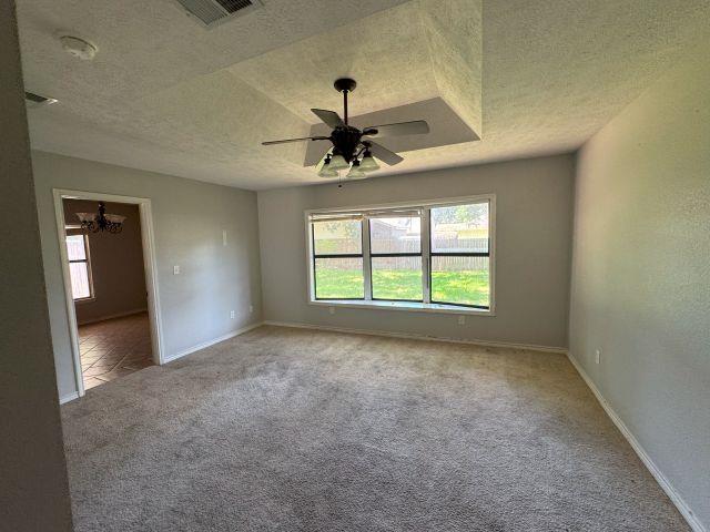 2985 Willow Pl, Beaumont, TX 77707 - empty room with a textured ceiling, plenty of natural light, carpet floors, ceiling fan, and a smoke detector