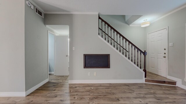 entryway featuring light hardwood / wood-style floors and ornamental molding