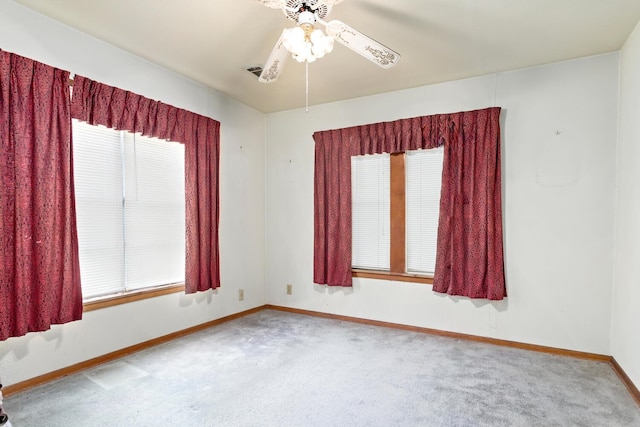 carpeted empty room with baseboards and a ceiling fan