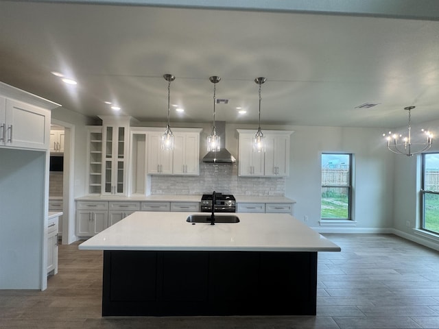 14865 Norma Jane Ln, Beaumont, TX 77713 - kitchen with wall chimney exhaust hood, stainless steel range with gas stovetop, backsplash, white cabinets, and light countertops
