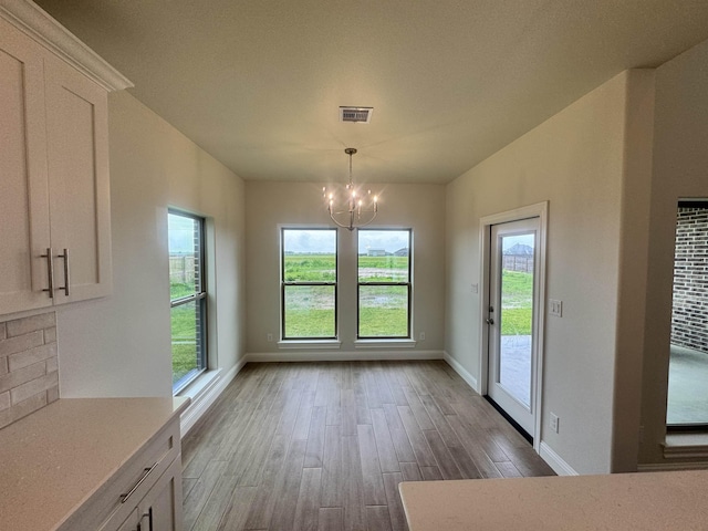 14865 Norma Jane Ln, Beaumont, TX 77713 - unfurnished dining area with a chandelier, wood finished floors, and baseboards