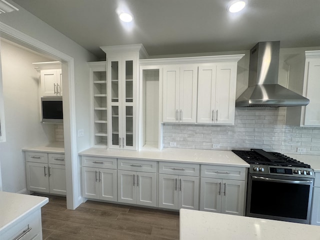 14865 Norma Jane Ln, Beaumont, TX 77713 - kitchen featuring stainless steel gas range, wall chimney range hood, backsplash, white cabinets, and light countertops