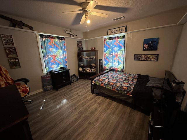 bedroom with ceiling fan, wood-type flooring, and a textured ceiling