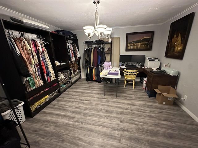 spacious closet with hardwood / wood-style flooring and a notable chandelier