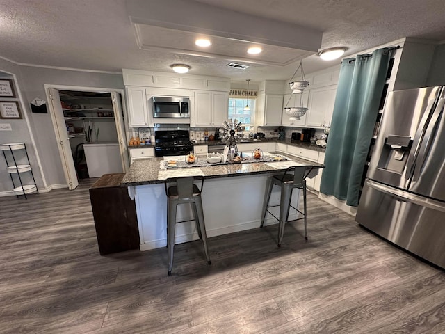 kitchen featuring appliances with stainless steel finishes, white cabinetry, and a kitchen island