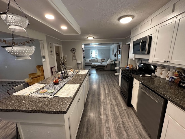 kitchen featuring white cabinetry, crown molding, decorative light fixtures, a textured ceiling, and appliances with stainless steel finishes