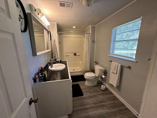 bathroom featuring ornamental molding, vanity, a textured ceiling, hardwood / wood-style floors, and toilet