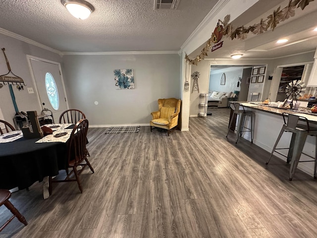 dining room featuring a textured ceiling, hardwood / wood-style flooring, and crown molding