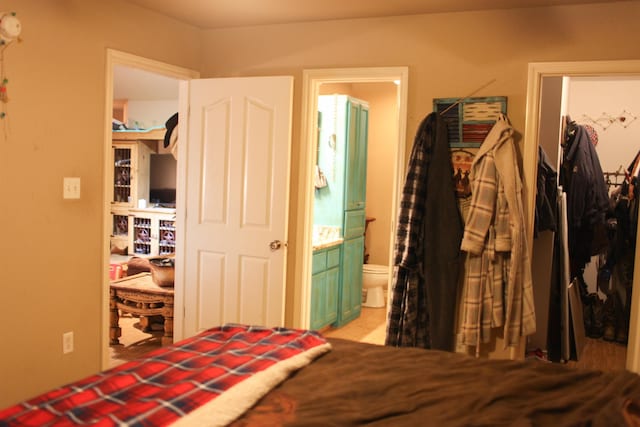 bedroom featuring a spacious closet, connected bathroom, and a closet