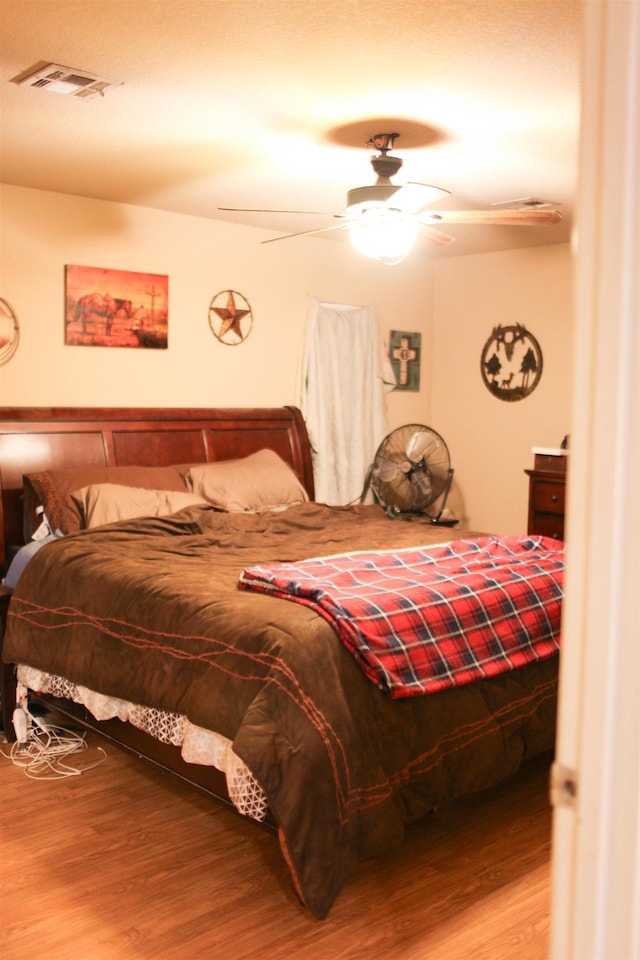 bedroom with ceiling fan and hardwood / wood-style flooring