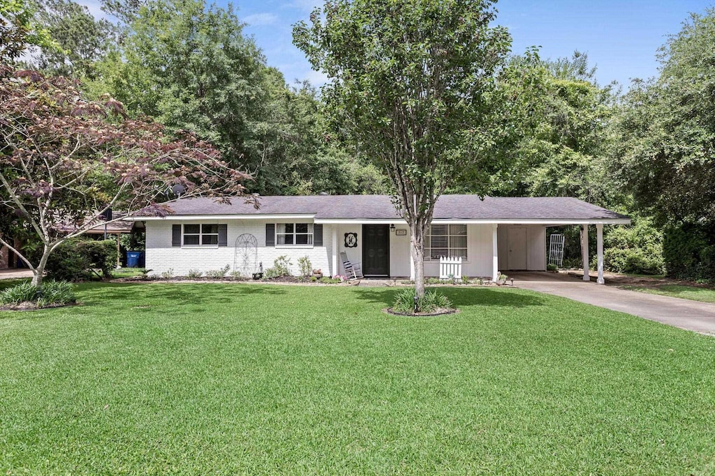 317 Pinewood, Silsbee, TX 77656 - ranch-style house featuring a carport, driveway, and a front lawn