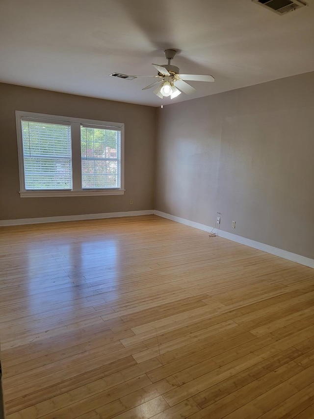 empty room with ceiling fan and light wood-type flooring