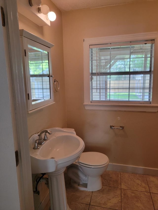 bathroom with toilet and tile patterned floors