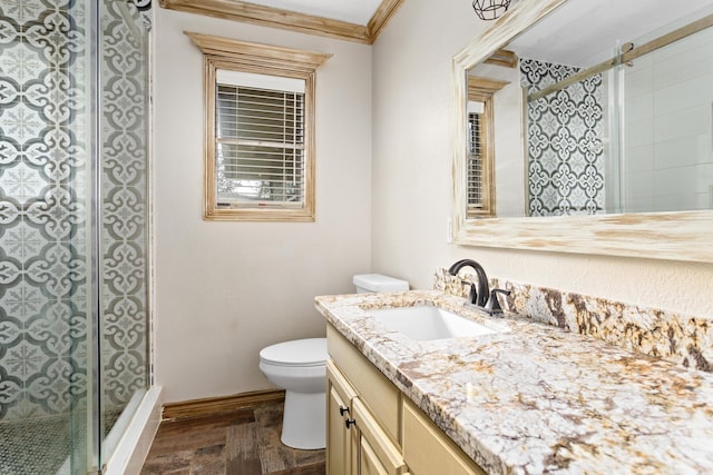 full bath featuring toilet, ornamental molding, a shower stall, vanity, and baseboards