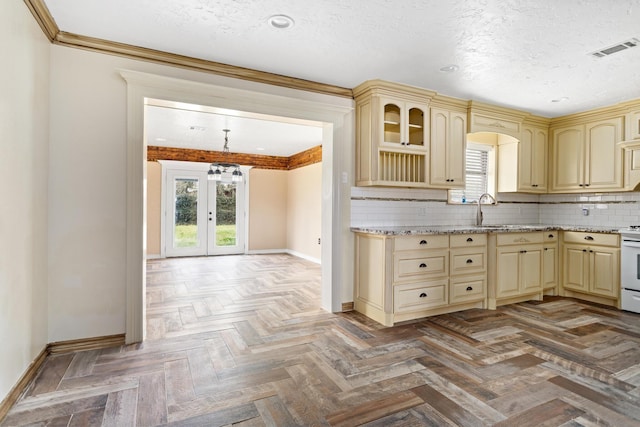 kitchen featuring plenty of natural light, visible vents, backsplash, and cream cabinetry