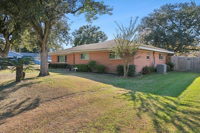 view of side of home with central AC unit and a yard