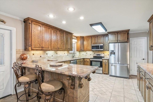 kitchen featuring a breakfast bar, stainless steel appliances, kitchen peninsula, and sink