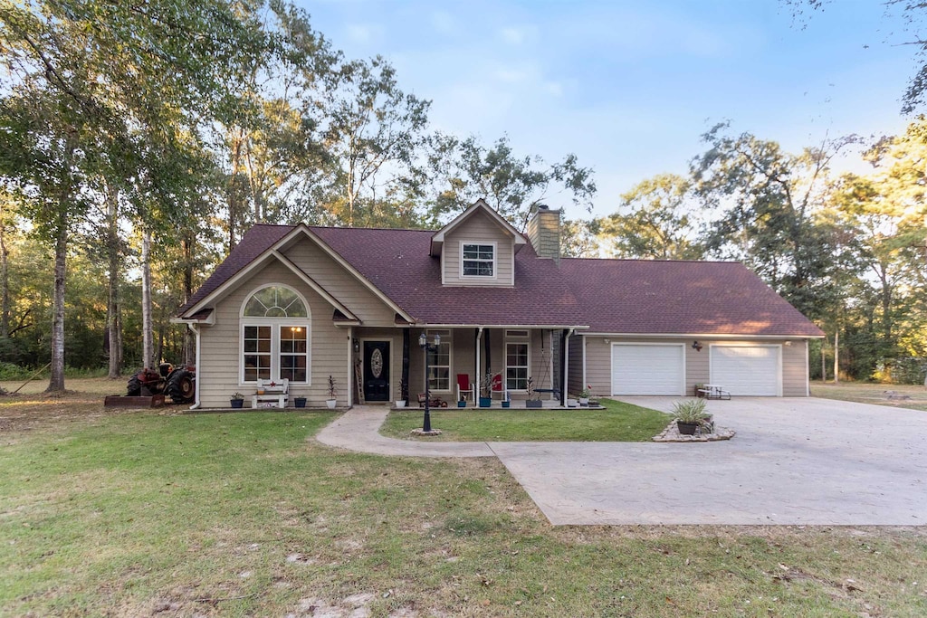 view of front of house featuring a front lawn, a porch, and a garage