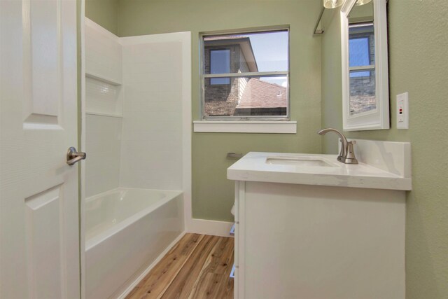 1105 W Dr, Port Neches, TX 77651 - bathroom featuring wood finished floors, vanity, toilet, baseboards, and bathtub / shower combination