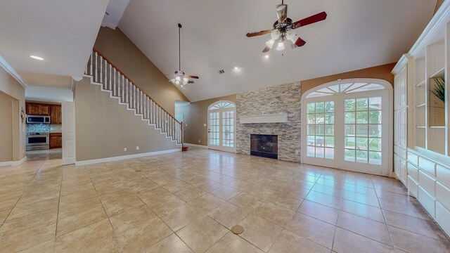 13475 Chimney Rock Dr, Beaumont, TX 77713 - unfurnished living room with ceiling fan, high vaulted ceiling, light tile patterned floors, a stone fireplace, and stairway
