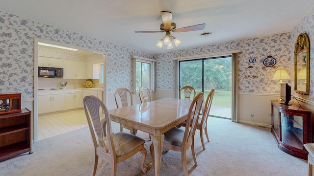 6225 Pansy Dr, Beaumont, TX 77706 - dining space featuring wallpapered walls, wainscoting, ceiling fan, and light colored carpet