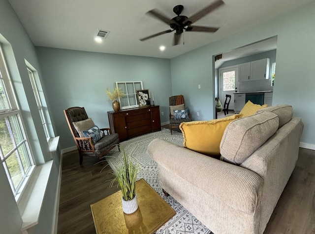 living room featuring ceiling fan and dark wood-type flooring