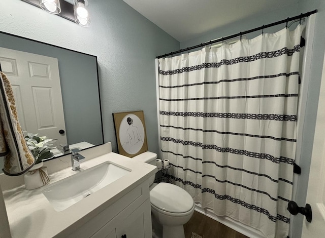 bathroom with hardwood / wood-style flooring, vanity, toilet, and walk in shower