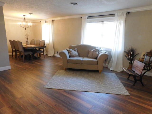 living area featuring a textured ceiling, baseboards, wood finished floors, and ornamental molding