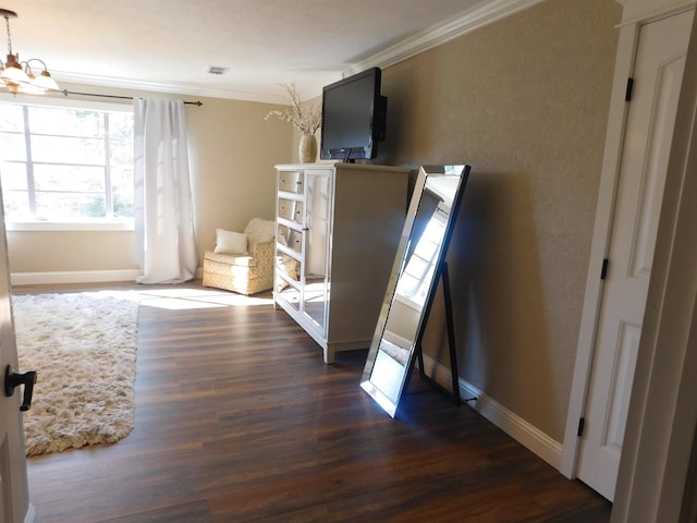 unfurnished bedroom featuring a notable chandelier, baseboards, dark wood finished floors, and crown molding