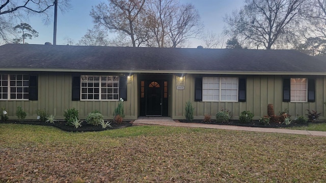 single story home with roof with shingles, a front lawn, and board and batten siding