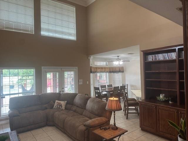 10994 Bessie Heights Rd, Orange, TX 77630 - living area with light tile patterned flooring, a towering ceiling, a ceiling fan, french doors, and healthy amount of natural light