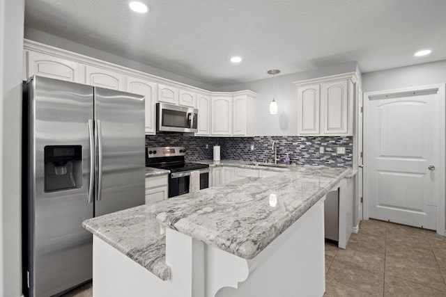 6605 Palace Dr, Lumberton, TX 77657 - kitchen featuring appliances with stainless steel finishes, a sink, a center island, decorative backsplash, and recessed lighting