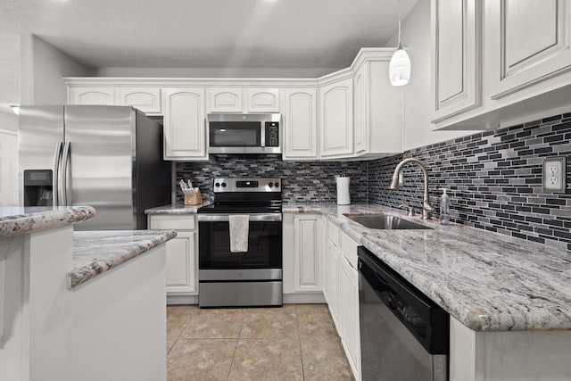 6605 Palace Dr, Lumberton, TX 77657 - kitchen featuring stainless steel appliances, a sink, white cabinets, decorative backsplash, and light stone countertops