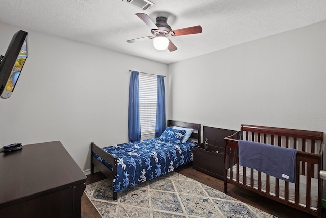 6605 Palace Dr, Lumberton, TX 77657 - bedroom with wood finished floors, a textured ceiling, and a ceiling fan