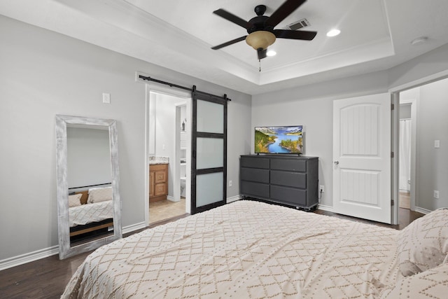 6605 Palace Dr, Lumberton, TX 77657 - bedroom with a barn door, a tray ceiling, ornamental molding, dark wood-style flooring, and baseboards