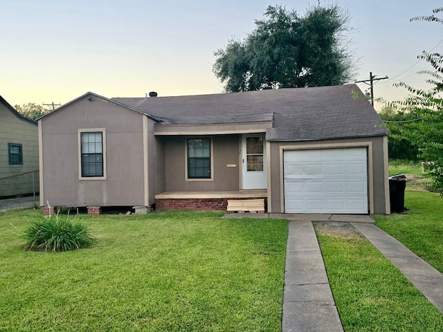 ranch-style home featuring a lawn and a garage