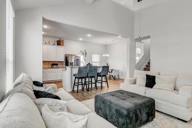 1560 Alice Dr, Beaumont, TX 77705 - living area with a chandelier, light wood-type flooring, high vaulted ceiling, stairway, and recessed lighting