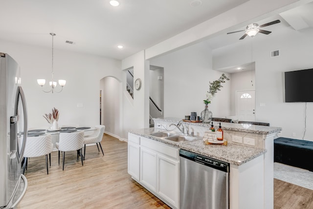 1560 Alice Dr, Beaumont, TX 77705 - kitchen featuring appliances with stainless steel finishes, a sink, arched walkways, ceiling fan, and light wood-type flooring