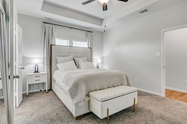 1560 Alice Dr, Beaumont, TX 77705 - carpeted bedroom featuring a tray ceiling, baseboards, and a ceiling fan