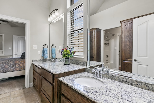 bathroom featuring vanity, tile patterned flooring, lofted ceiling, and washtub / shower combination