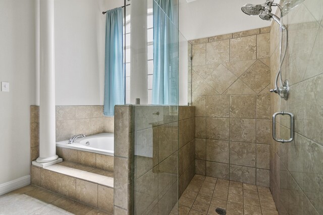 bathroom with independent shower and bath, plenty of natural light, and decorative columns