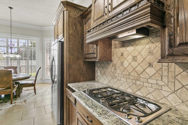 kitchen with premium range hood, appliances with stainless steel finishes, decorative backsplash, crown molding, and light stone countertops