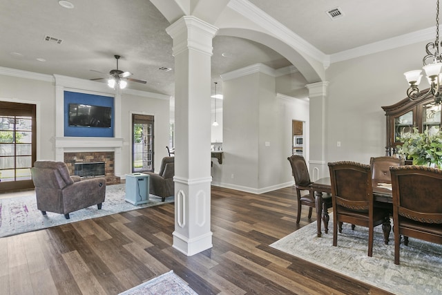 dining area featuring a fireplace, decorative columns, and a wealth of natural light