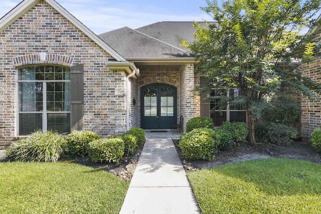 doorway to property featuring french doors and a lawn